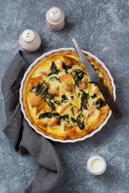 Kırmızı balık ve hafif ahşap zemin üzerine ıspanak ile ev yapımı kiş tart. Vintage tarzı. Üstten Görünüm.