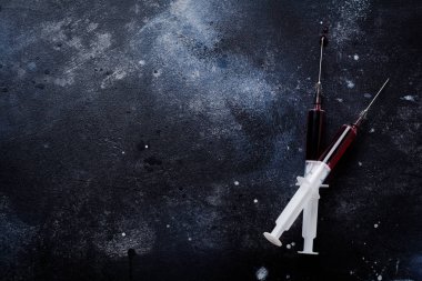 Eski beton arka planda kan ile şırınga. Üst görünüm.