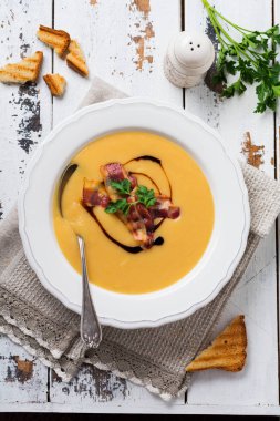 Beyaz kase pastırma ve soya sosu ile Patates çorbası krem, açık eski ahşap arka plan üzerinde. Üstte görüntü.