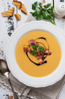 Beyaz kase pastırma ve soya sosu ile Patates çorbası krem, açık eski ahşap arka plan üzerinde. Üstte görüntü.