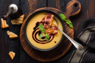 Siyah kase pastırma ve soya sosu ile Patates çorbası krem, koyu eski beton arka plan üzerinde. Üstte görüntü.