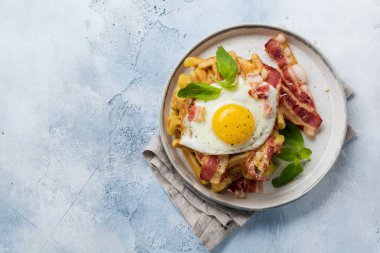 Hafif eski beton arka plan üzerinde kahvaltı için kızarmış pastırma, yumurta ve baharat ve fesleğen ile parmesan peyniri ile Peynir Waffle. Üstte görüntü.