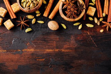 Eski ahşap arka plan üzerinde yıldız anason, kakule, tarçın ve kahverengi şeker baharat seti. Düz yatıyordu