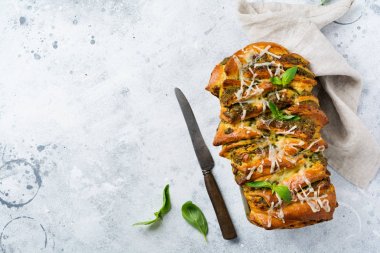 İtalyan makarna pesto, fesleğen ve parmesan peyniri ile pull-apart ekmek eski hafif beton arka plan üzerinde pişirme şeklinde. Üst te. Rustik stile. 