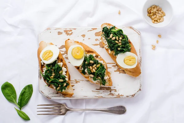 Stekt Spenat Ägg Och Pinjenötter Smörgåsar Eller Bruschetta Ljus Bakgrund — Stockfoto