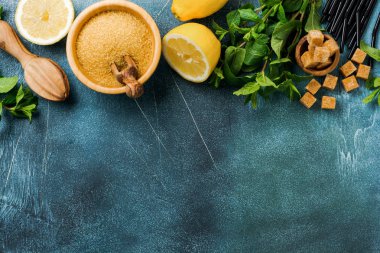 Eski beton arka plan üzerinde ev yapımı ferahlatıcı limon suyu limonata, şeker kamışı ve nane için malzemelerle Konsept.