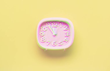 Sarı arka planda pembe çalar saat nesnesi. Glitch tarzı etkisi. Canlı duotone sarı, mor renkler. Üstte görüntü.