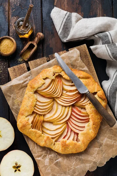 Apple galette, pie, cake with honey and cane sugar on a wooden background. Copy space. Top view
