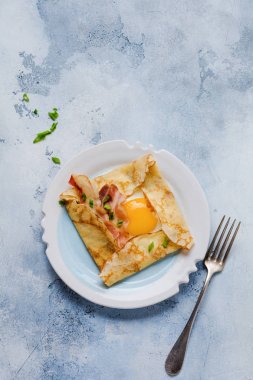 Sahanda yumurta, peynir, pastırma ve yeşil soğan bir ışık gri beton zemin üzerine kahvaltıda krep.