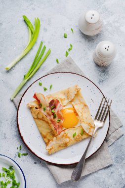 Sahanda yumurta, peynir, pastırma ve yeşil soğan bir ışık gri beton zemin üzerine kahvaltıda krep.