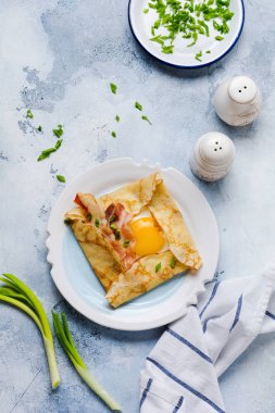 Sahanda yumurta, peynir, pastırma ve yeşil soğan bir ışık gri beton zemin üzerine kahvaltıda krep.
