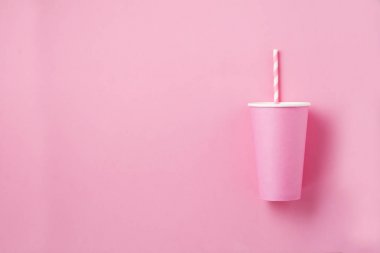 Pembe kağıt ışık arka plan üzerinde kahve bir pembe kağıt fincan. Sıfır atık kavramı. Düz yatıyordu.