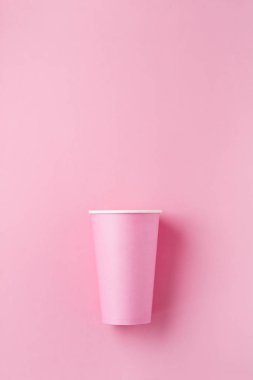 Pembe kağıt ışık arka plan üzerinde kahve bir pembe kağıt fincan. Sıfır atık kavramı. Düz yatıyordu.