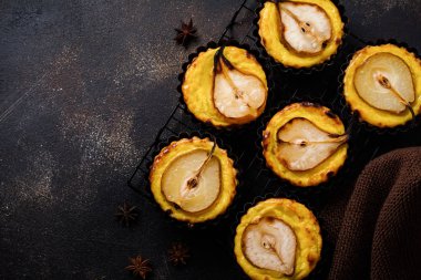 Armut ve koyu kahverengi beton eski tablo arka plan üzerinde muhallebi mini turta. Üstten görünüm.