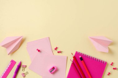 Defter, renkli kalemler, cetvel, kalem, silgi, keskinleştirme ve daha fazlası. Sarı arka planda okul ve ofis kırtasiye. Kavram okula geri döndü. Üstte görüntü.
