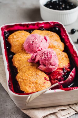 Ahududu ve siyah kuş üzümü pasta pişirme çanağı içinde ahududu dondurma ile. Ev yapımı meyve pasta hamur işleri. Gri antika arka plan. Üstten görünüm.