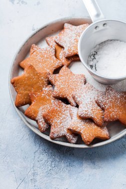 Ev yapımı yılbaşı yeni yıl yıldız şekli gingerbread çerezleri eski beton gri antika arka plan üzerinde seramik plaka. Üstten görünüm alanı ile.