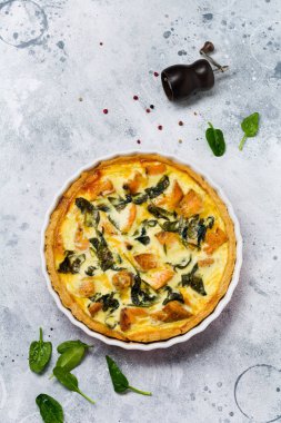 Kırmızı balık ve hafif ahşap zemin üzerine ıspanak ile ev yapımı kiş tart. Vintage tarzı. Üstten Görünüm.