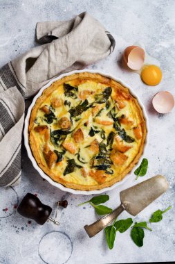 Kırmızı balık ve hafif ahşap zemin üzerine ıspanak ile ev yapımı kiş tart. Vintage tarzı. Üstten Görünüm.