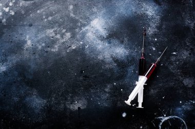 Eski beton arka planda kan ile şırınga. Üst görünüm.