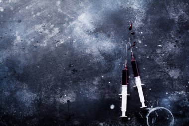 Eski beton arka planda kan ile şırınga. Üst görünüm.