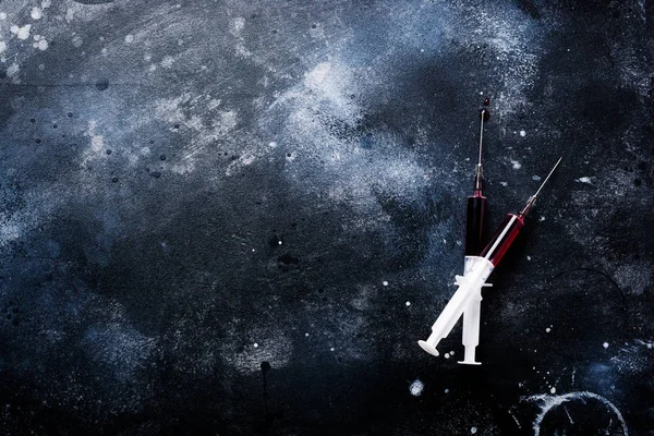 Eski beton arka planda kan ile şırınga. Üst görünüm.