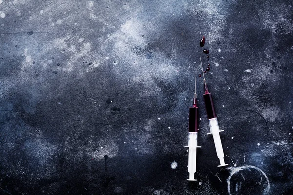 Eski beton arka planda kan ile şırınga. Üst görünüm.