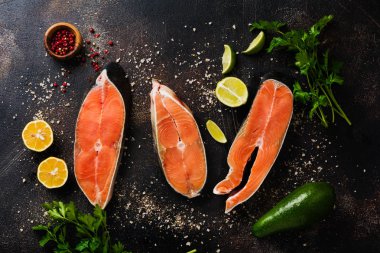 Oda arkadaşı somon ile baharat, ot, tuz ve limon eski taş zemin üzerine çiğ biftek. Üstten görünüm kopya alanı.