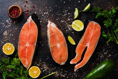 Oda arkadaşı somon ile baharat, ot, tuz ve limon eski taş zemin üzerine çiğ biftek. Üstten görünüm kopya alanı.