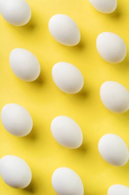 Beyaz çiğ tavuk yumurtası açık beton arka plan üzerinde yatıyor. Üstte görüntü.