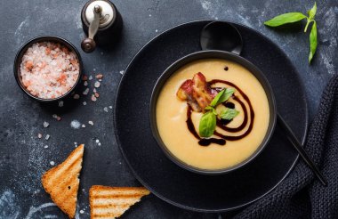 Siyah kase pastırma ve soya sosu ile Patates çorbası krem, koyu eski beton arka plan üzerinde. Üstte görüntü.