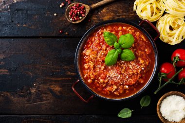 Sos tenceresinde geleneksel İtalyan Bolognese sosu eski koyu ahşap arka plan. Üst görünüm, kopyalama alanı
