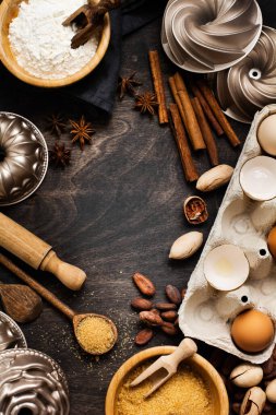 Un, şeker, baharat, tarçın, ahşap kaşık ve eski, siyah ahşap arka planda merdaneyle pişirme ve aşçılık. Kopyalama alanı olan üst görünüm.