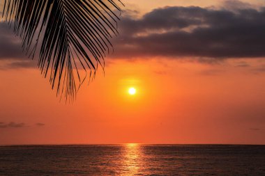 Hermoso atardecer a la orilla del mar con nubes oscuras en el cielo