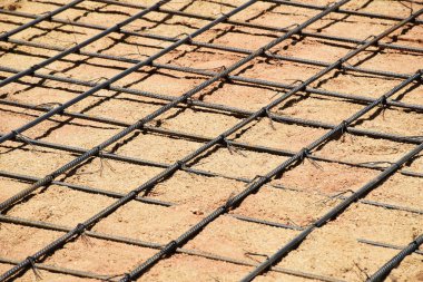 Yuvarlak çelik kalıpları sıkıştırılmış kumun üzerine yerleştiriliyor ve beton zemine hazırlanıyor. Yapı ve mühendislik kavramları.