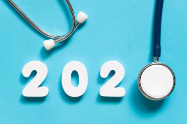 Mavi arka planda steteskop w / 2020 numarası. Sağlık hizmetleri ve sağlık afişi ve takvim kapağı için mutlu yıllar. Tıp tedavi ve tanı konseptinde yeni bir eğilim için yaratıcı fikir.
