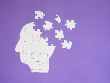 Beyaz yapboz, mor arka planda kopyalama alanı olan bir insan beyni. Hafıza kaybı, Alzheimer hastalığı, bunama, Parkinson hastalığı, duygu stresi ve akıl sağlığı konsepti için yaratıcı bir fikir.