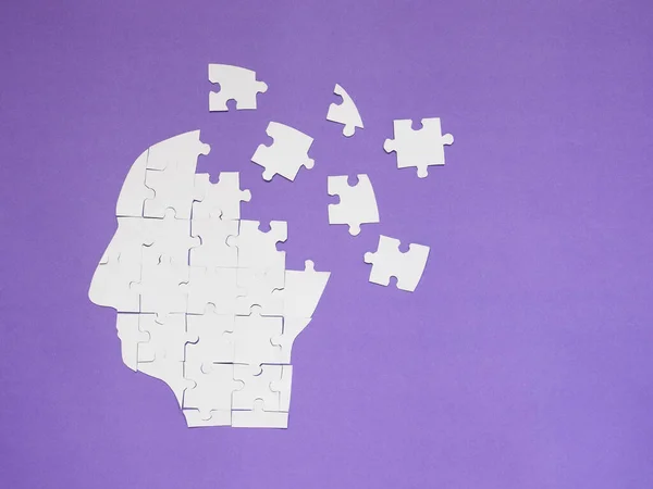 白色拼图作为一个人的大脑在紫色背景和复制空间 记忆力丧失 老年痴呆症 痴呆症 帕金森症 情绪紧张和精神健康概念的创意概念 — 图库照片