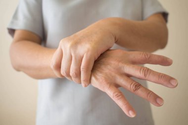 Parkinson hastalığı belirtileri. Parkinson hastası orta yaşlı kadınların titreme (titreme) ellerini kapat. Zihinsel sağlık ve nörolojik bozukluklar.