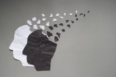 İnsan kafası tarafından sunulan bipolar bozukluk, gri arka planda yırtılan siyah ve beyaz buruşmuş kağıttan yapılmıştır. Manik ve depresif duygular. Akıl sağlığı, beyin rahatsızlığı ve psikolojik konsept.