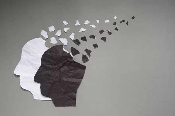 双相情感障碍是在灰色背景和 或复制空间上被撕碎的黑白相间的皱纹纸制成的人头 躁狂和压抑的情绪 精神健康 大脑紊乱和心理概念 — 图库照片