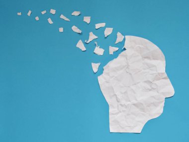 İnsan kafası tarafından sunulan beyin bozukluğu sembolü, buruşmuş kağıt şeklinde, mavi arka planda kopyalanmış. Alzheimer hastalığı, bunama, hafıza kaybı ve akıl sağlığı konsepti için yaratıcı bir fikir.