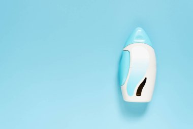 Açık mavi arka planda steroid burun spreyi süspansiyonu. Alerjik rhtis, saman nezlesi, sinüzit veya burun poliplerini tedavi etmek için kullanılan tıbbi bir cihaz. Sağlık hizmeti konsepti. Üst Manzara. Boşluğu kopyala.