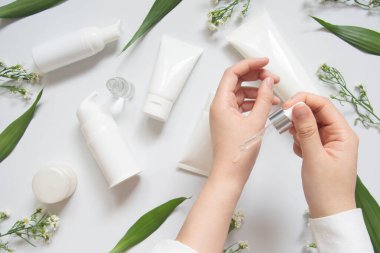 Dermatolog, beyaz masa üzerinde güvenlik ve etkinlik için organik doğal cilt bakım ürünlerini (serum, temel yağ, krem, losyon) test ediyor. Kozmetik güzellik ürünü laboratuvar test konsepti. Boşluğu kopyala.