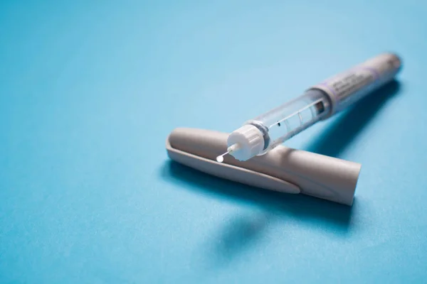 Insulinpenna Med Insulindroppe Vid Nålspetsen Ljusblå Bakgrund Medicintekniska Produkter Används — Stockfoto