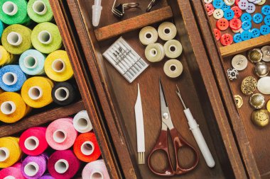 Eski ahşap kutuda aksesuarlar ve çok renkli iplikler dikmek, üst görünüm resmi