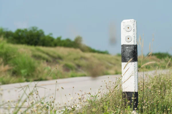 The guide post is right on the road warns car users to use the road. Perseverance concept