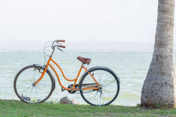 Orange bicycle with the backdrop of the mountains and the sea wi — Stock Photo, Image