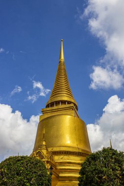 Bangkok 'taki Tayland tapınağında mavi gökyüzü ve beyaz bulut arka planıyla güzel bir altın stupa, Tayland.