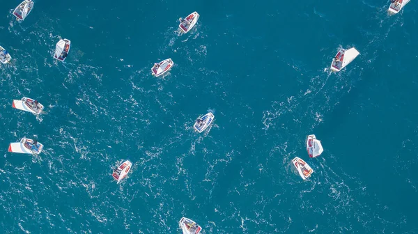 Skupina malých plachetnic manévrujících v klidných mořských vodách. Letecký pohled — Stock fotografie